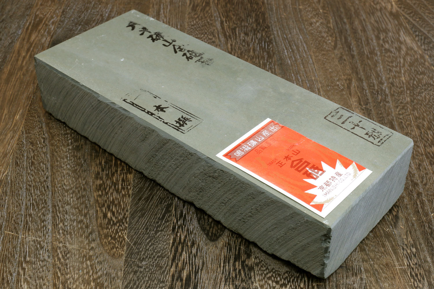 Natural sharpening whetstone, rectangular block with label on one end.