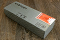 Natural sharpening whetstone in gray wrap with label stickers on one face
