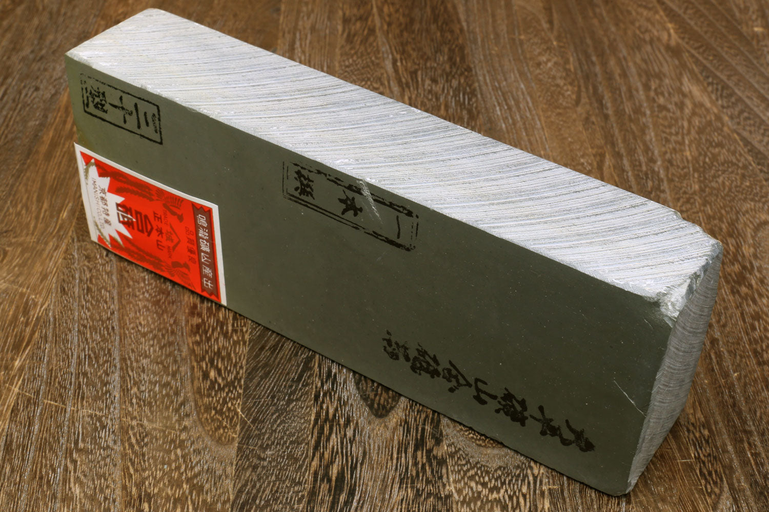Natural sharpening whetstone block with printed label panel and light stone face