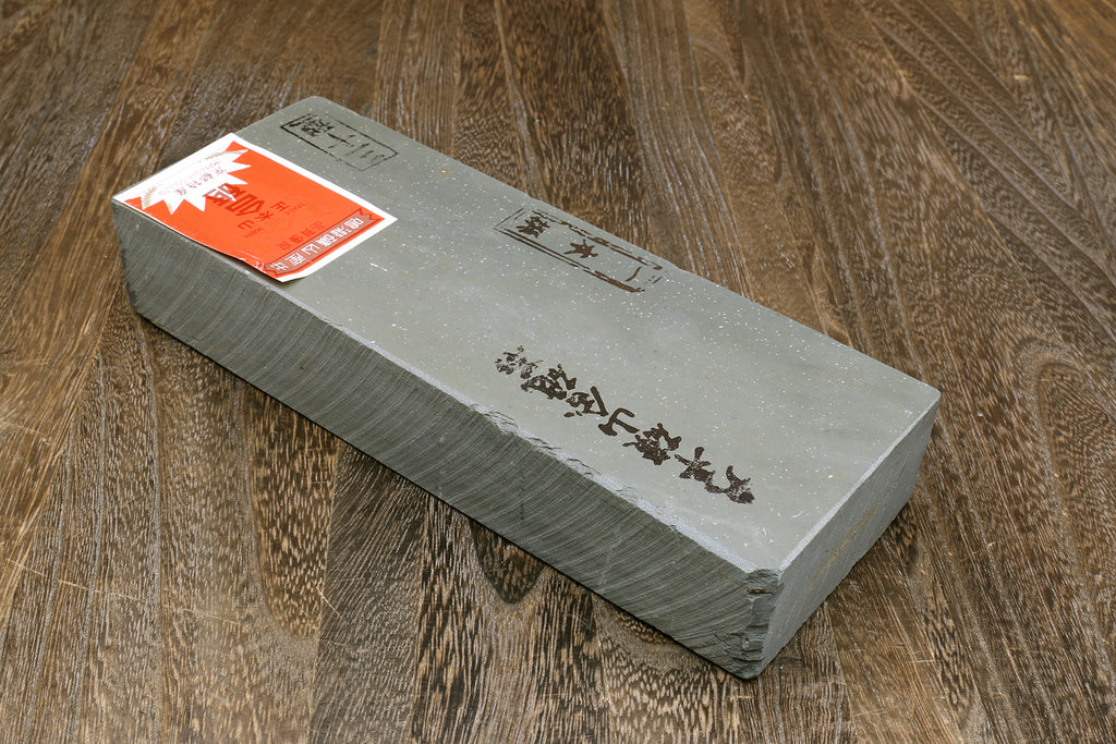 Natural sharpening whetstone with Japanese markings and orange label on end face