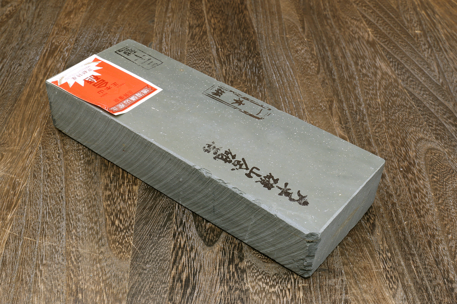 Natural sharpening whetstone with Japanese markings and orange label on end face