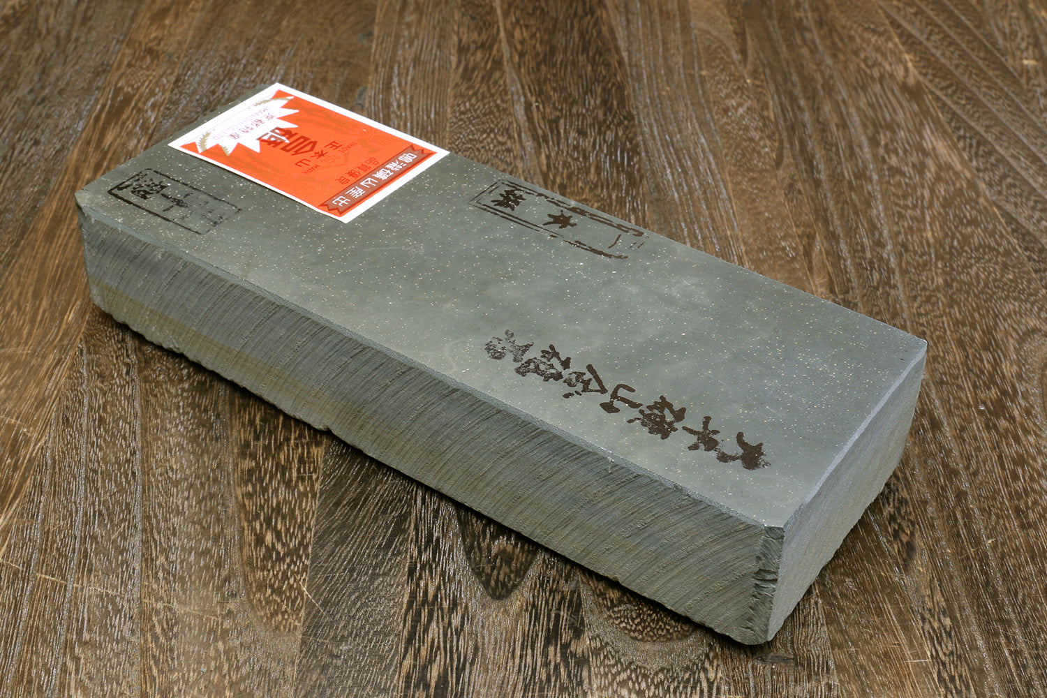 Natural sharpening whetstone, rectangular grey stone with paper label on top