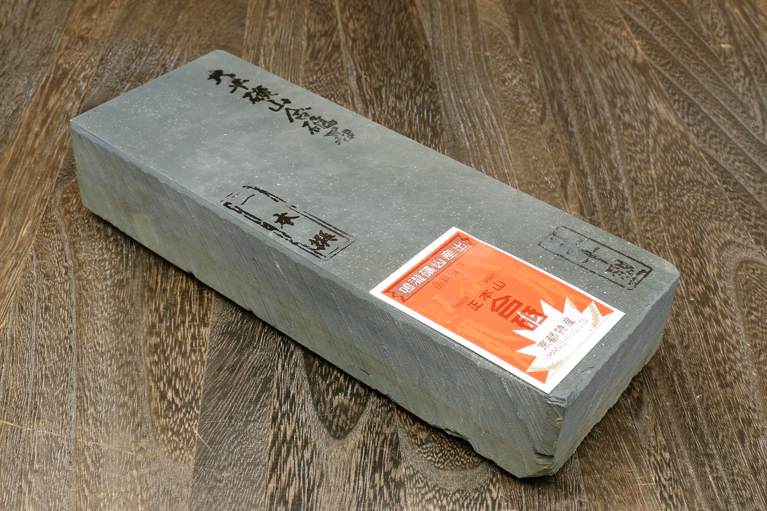 Natural sharpening whetstone, rectangular grey stone with orange label and black markings