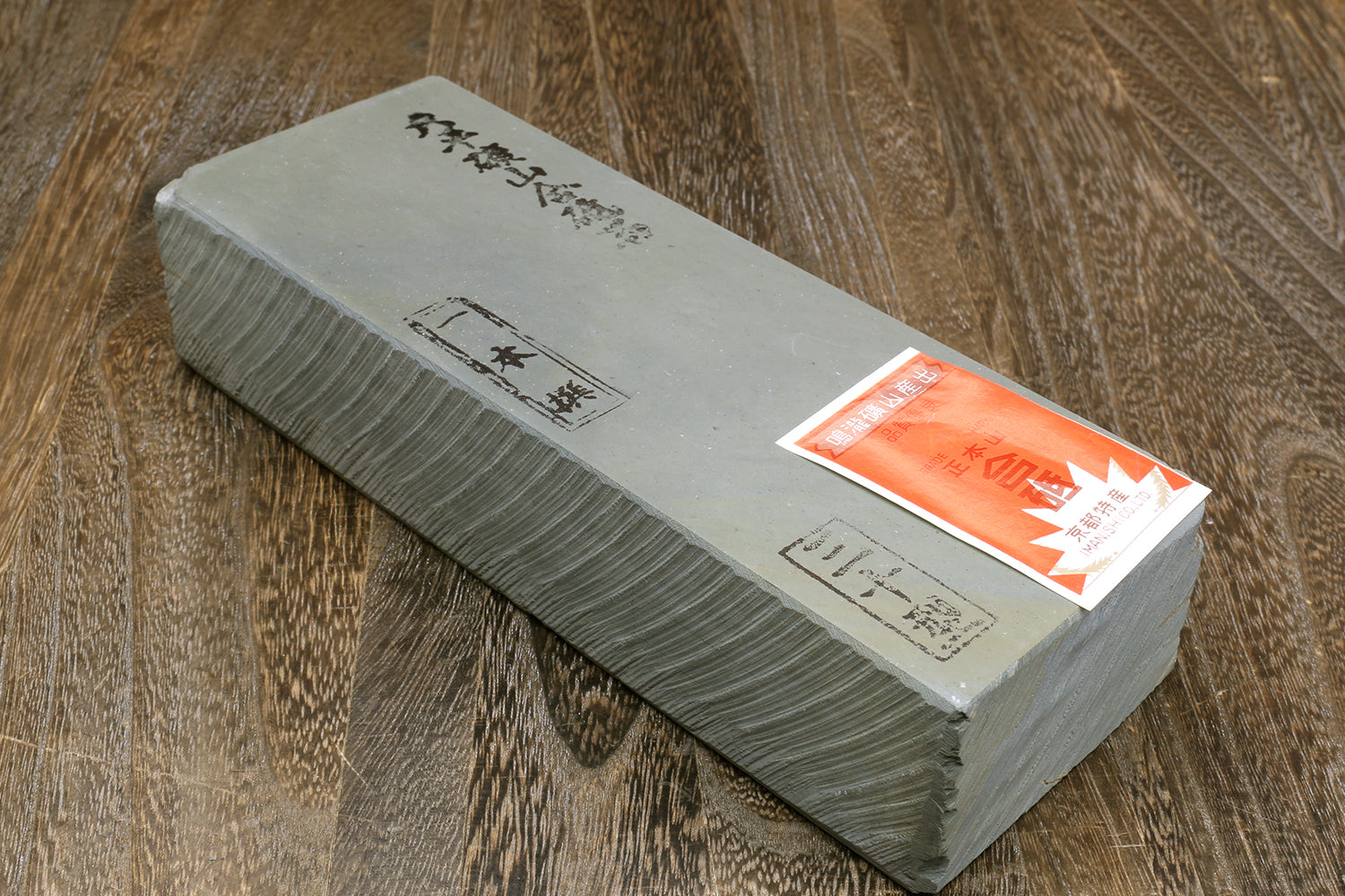 Natural sharpening whetstone, rectangular light gray with dark sides and product label