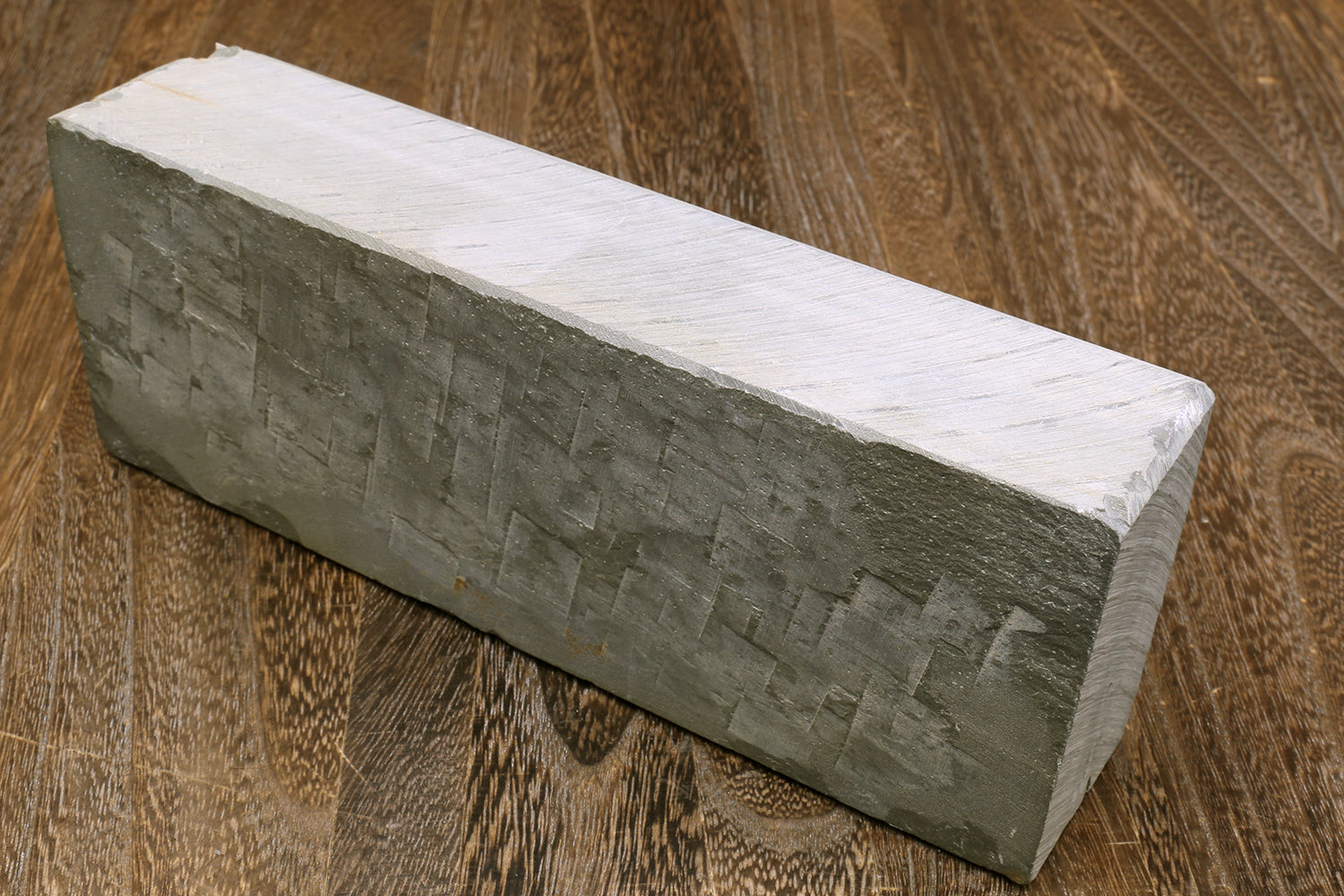 Natural sharpening whetstone block, rectangular light gray top and dark gray textured sides