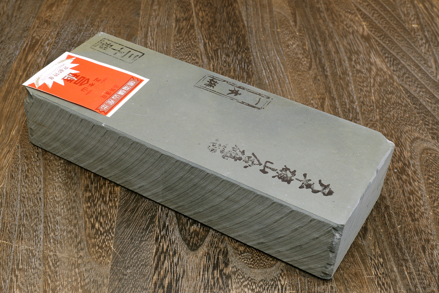 Natural sharpening whetstone, long rectangular light gray with orange label on side