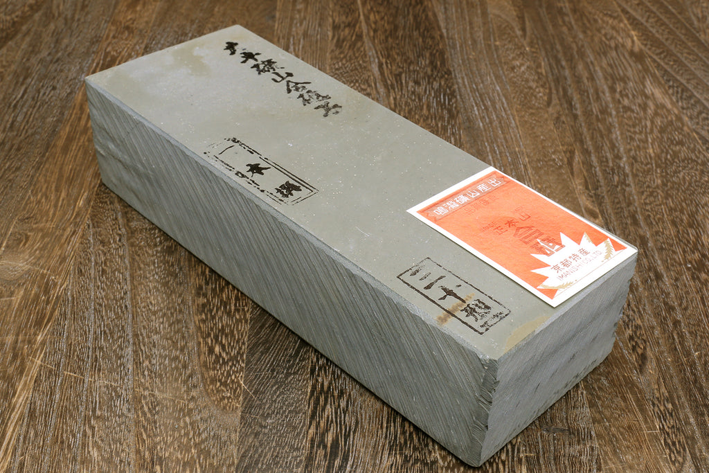 Natural sharpening whetstone, rectangular gray stone with orange label on end