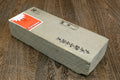 Natural sharpening whetstone, long cream block with orange packaging label on top
