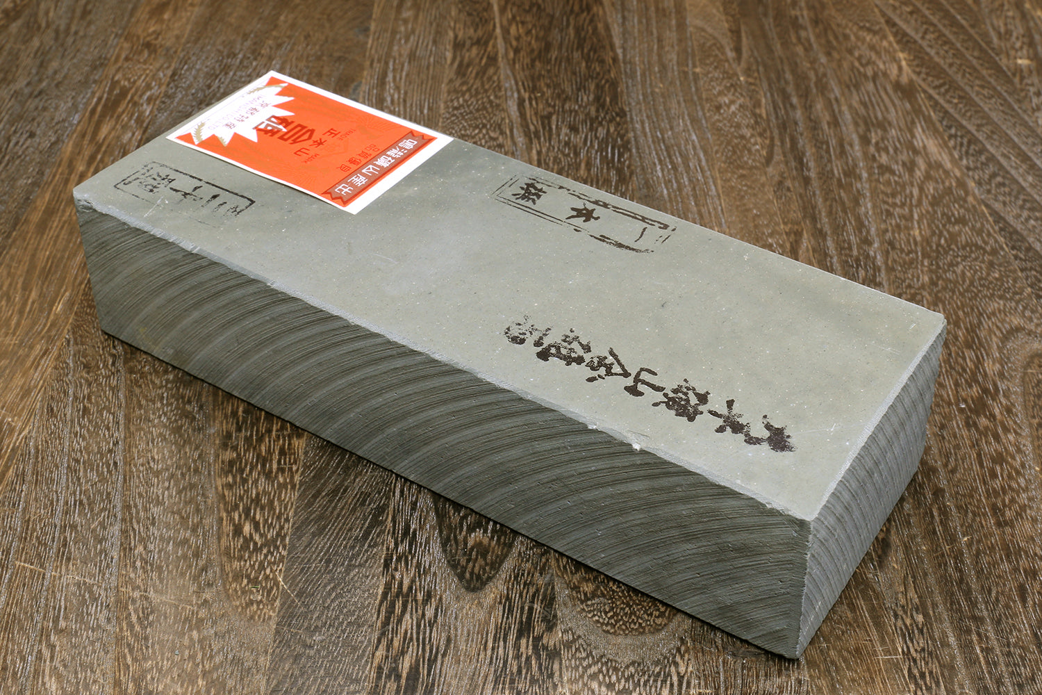 Yoshihiro natural finishing whetstone, light gray top with orange sticker and Japanese text