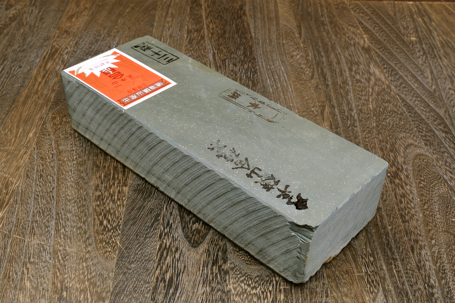 Natural whetstone finishing stone, grey rectangular bar with orange label on top