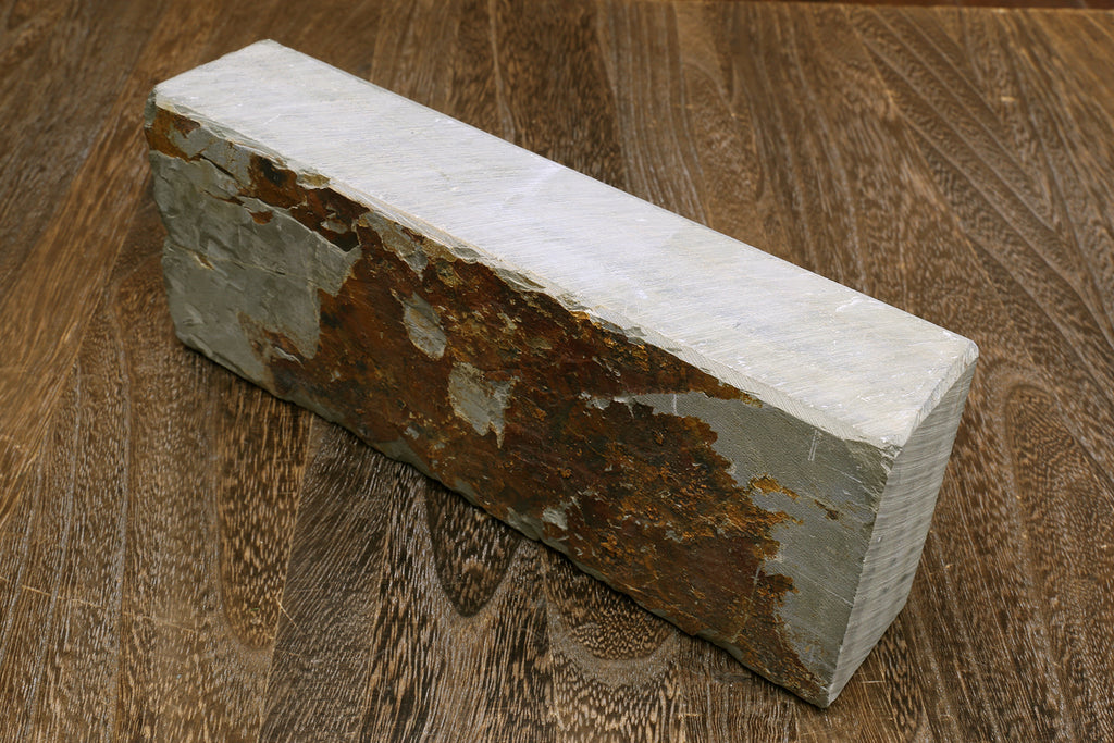 Natural whetstone block, gray stone with rough brown patches on side