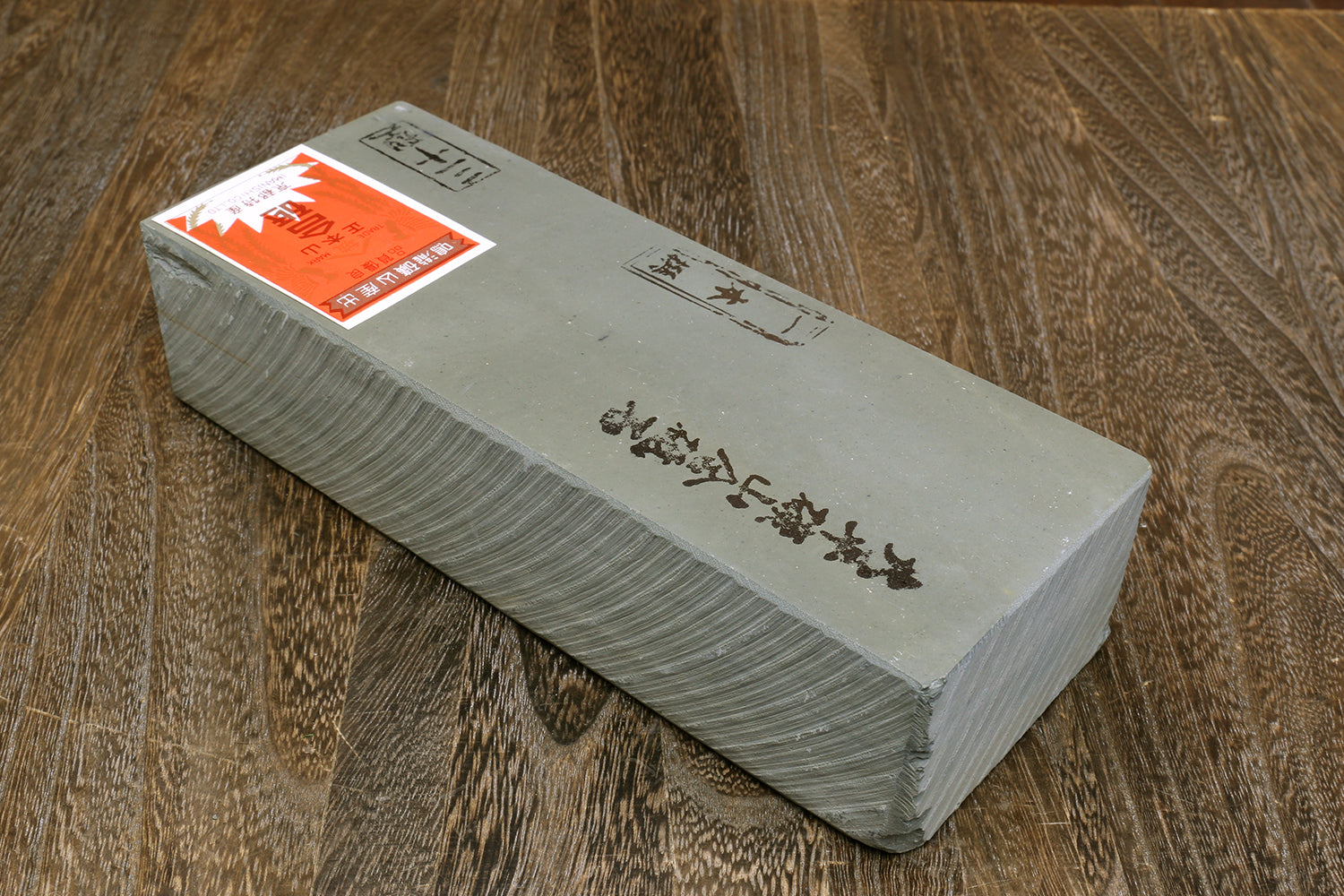 Rectangular whetstone sharpening stone, gray block with orange label and markings