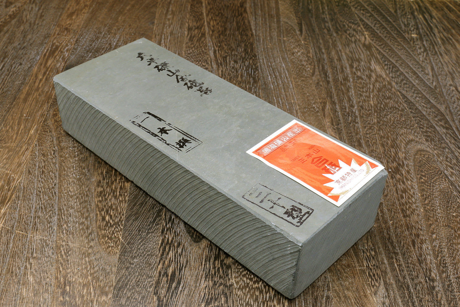 Rectangular gray whetstone with Japanese-style markings and orange sticker