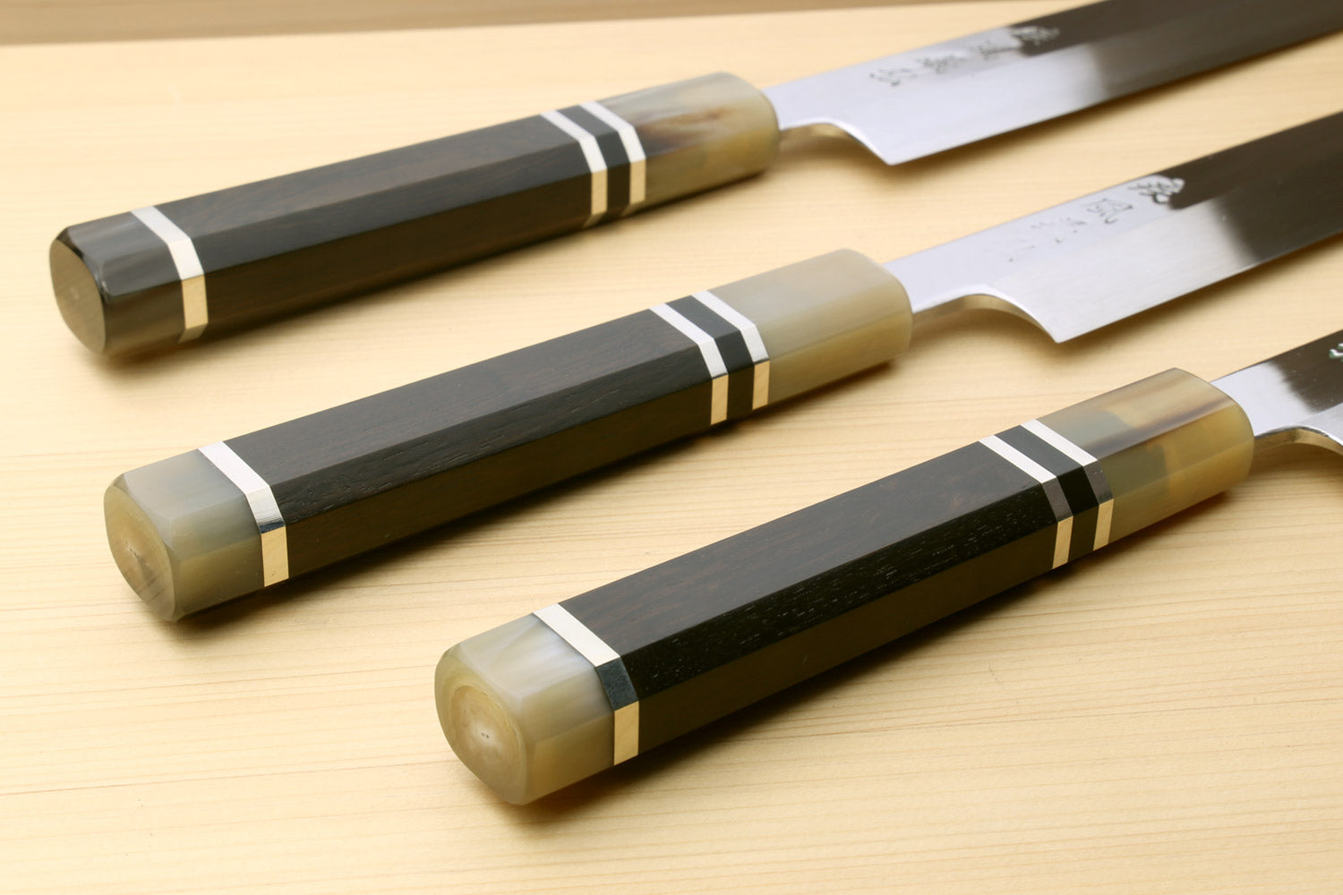 Set of Yanagi sushi knives with mirror blades and dark horn triple-ring handles