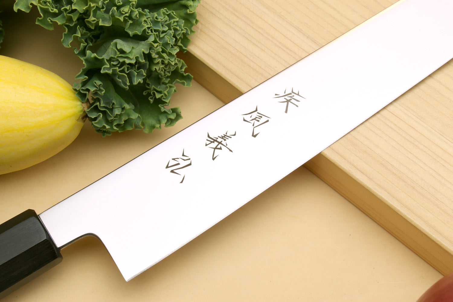Japanese slicer knife blade close-up with black bolster and etched markings