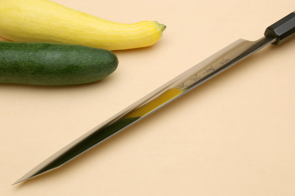 Japanese slicer knife with silver blade and dark black bolster on wood handle