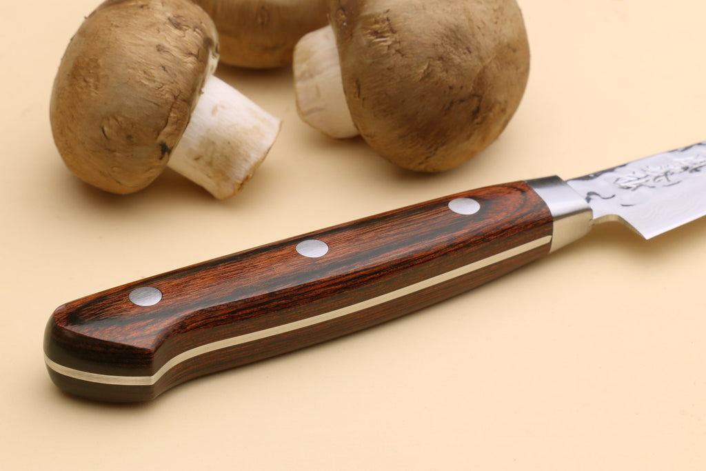 Paring knife with dark brown wood handle and hammered Damascus blade, side view
