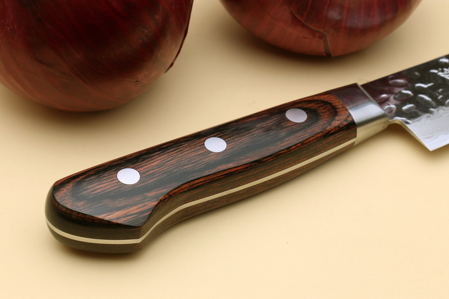Sujihiki chef knife handle with dark wood scales, metal rivets, and Damascus blade