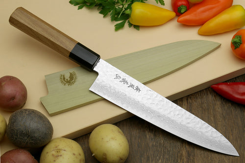 Damascus gyuto chef's knife with black bolster, light handle, and pointed blade