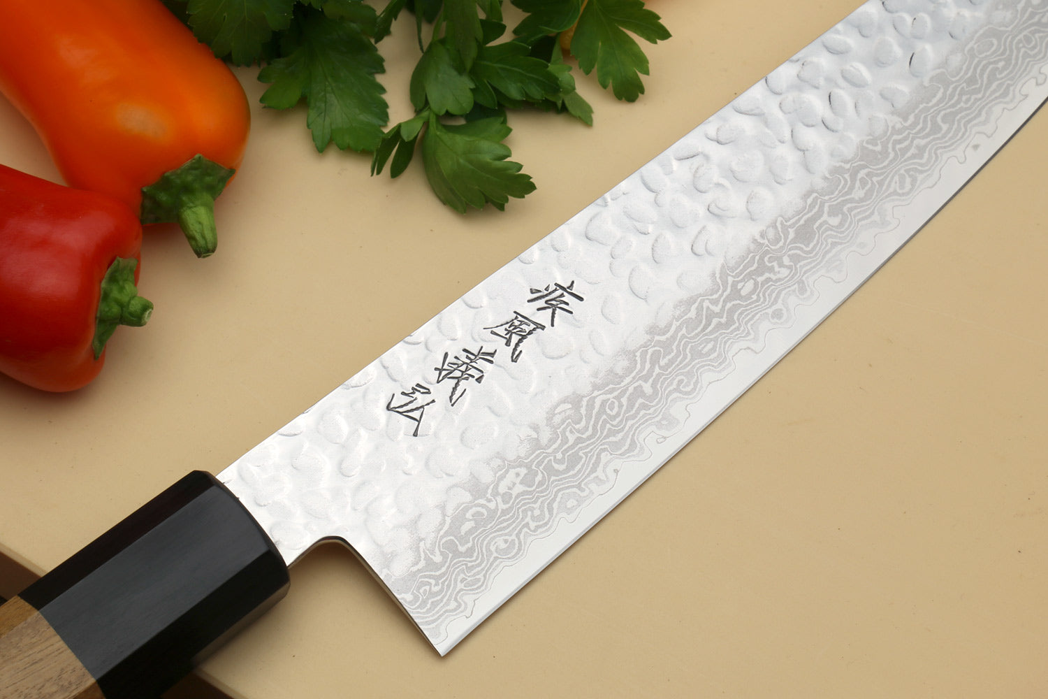 Damascus gyuto chef's knife with black bolster and engraved blade surface