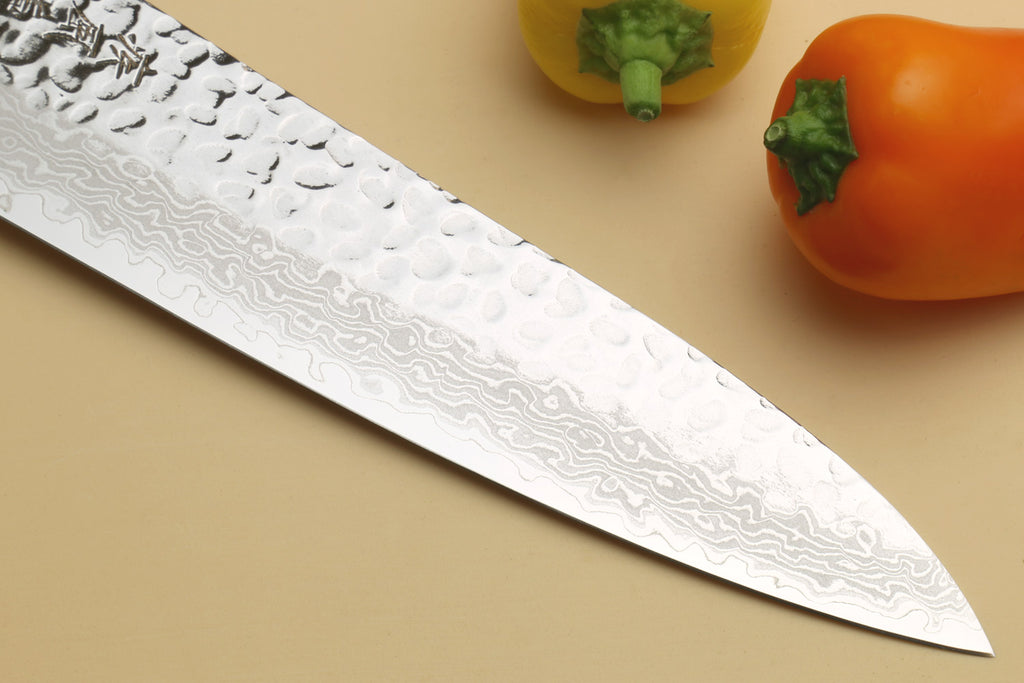 Japanese chef's knife with hammered Damascus blade tip and dark octagonal rosewood handle