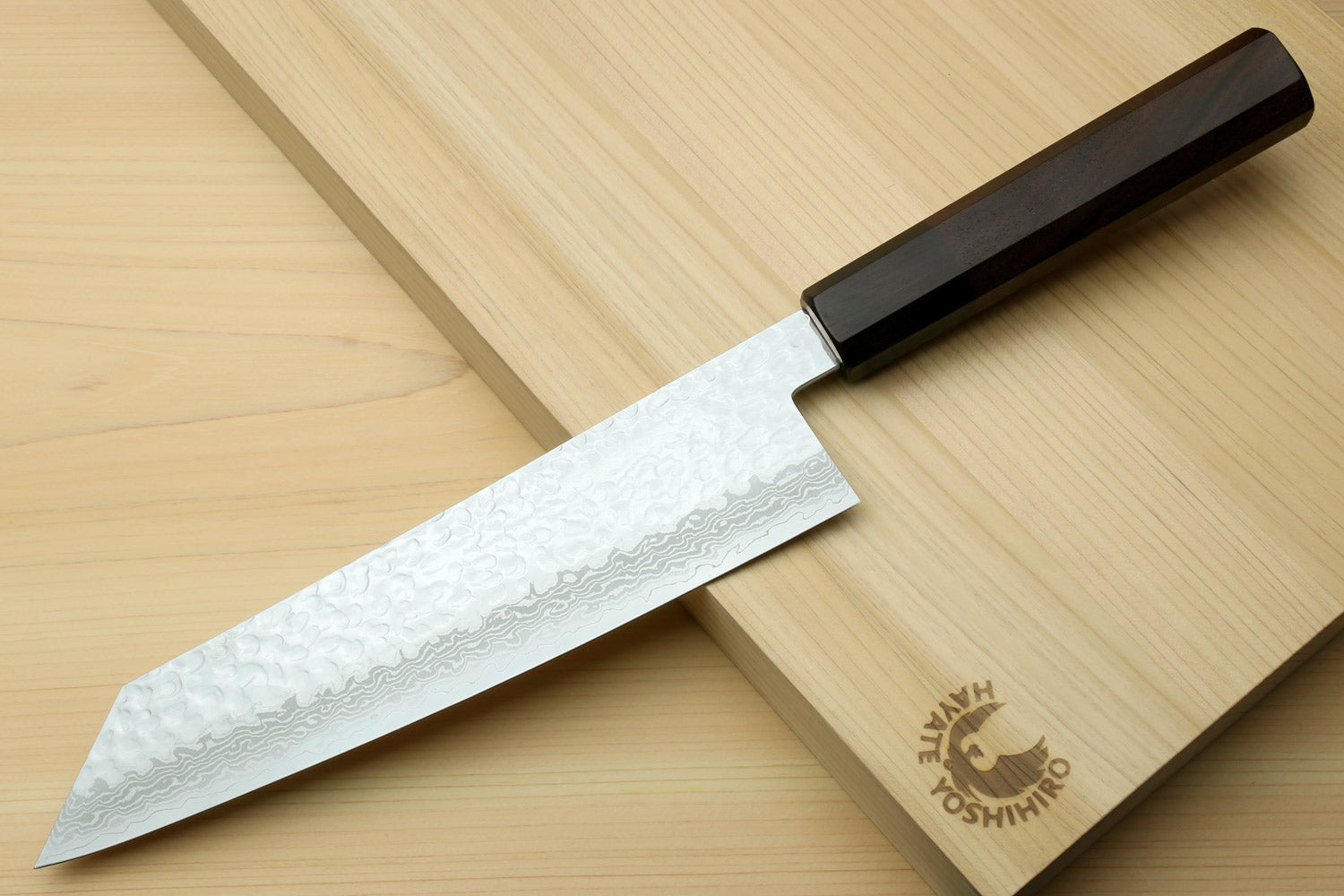 Kiritsuke Japanese chef knife with hammered Damascus blade and octagonal dark wood handle