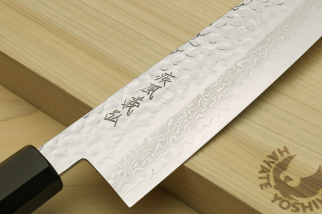 Kiritsuke knife blade with hammered Damascus pattern and engraved characters near the spine