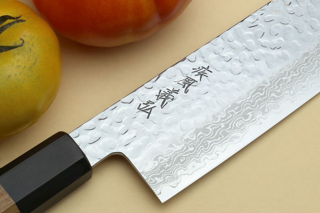 Nakiri vegetable knife close-up: hammered Damascus blade with engraved markings