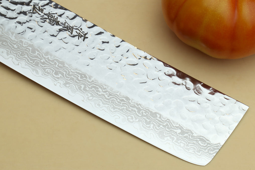 Nakiri vegetable knife blade close-up with hammered Damascus texture and rounded tip
