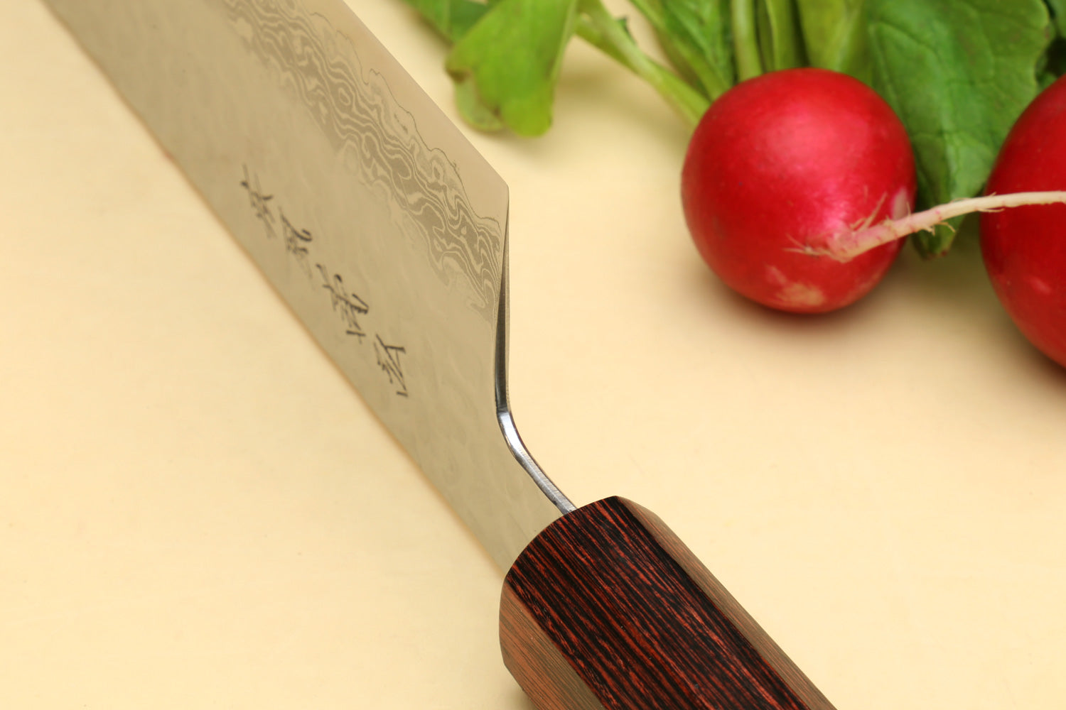 Nakiri vegetable knife close-up of Damascus blade engraving and rosewood handle