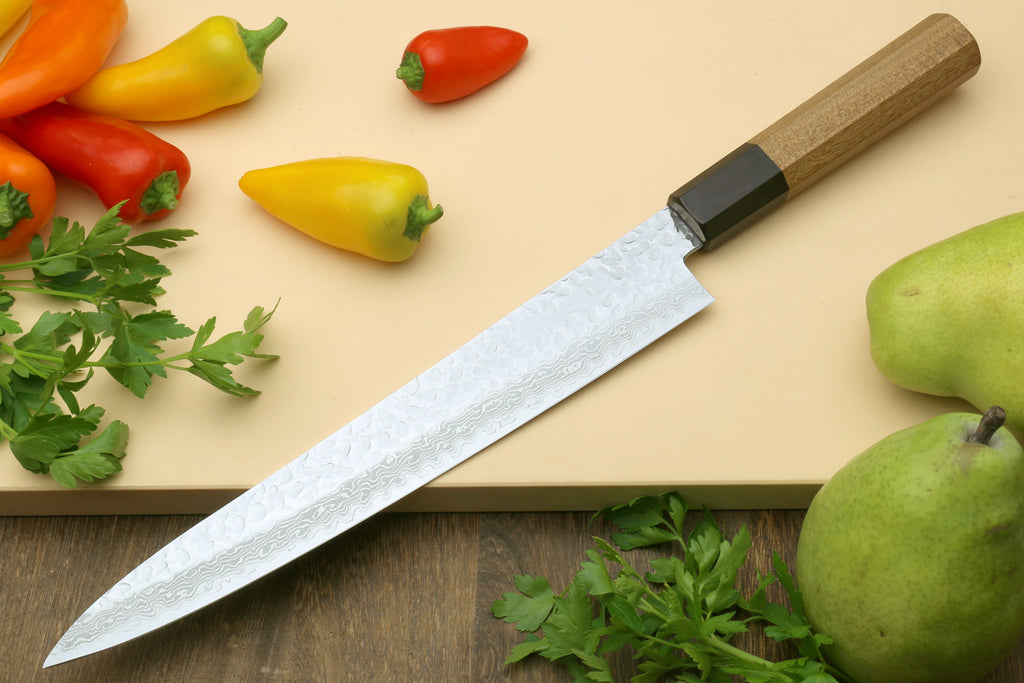 Japanese sujihiki knife with long Damascus blade and dark bolster on wood handle