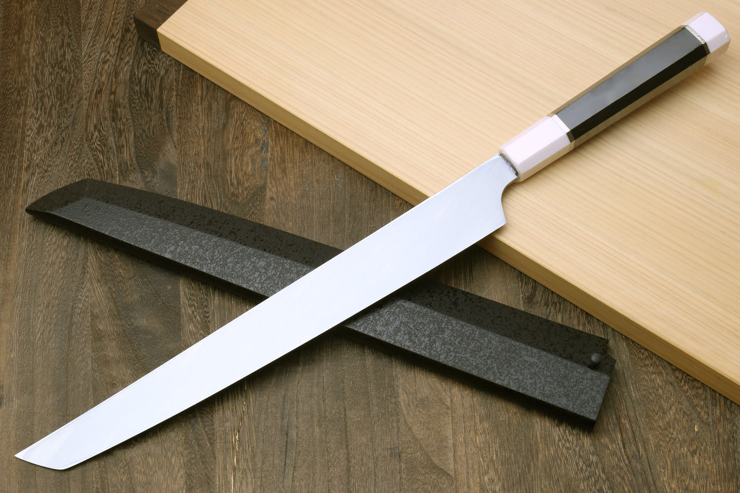 Japanese sushi sashimi knife angled with pointed dark blade and white handle ferrules