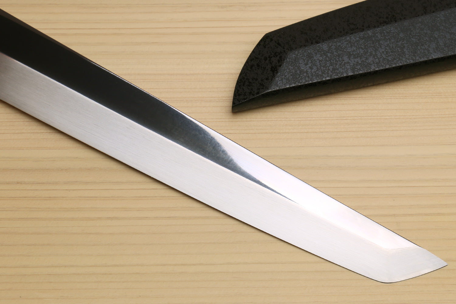 Japanese sushi sashimi knife blade close-up with dark steel and white spine