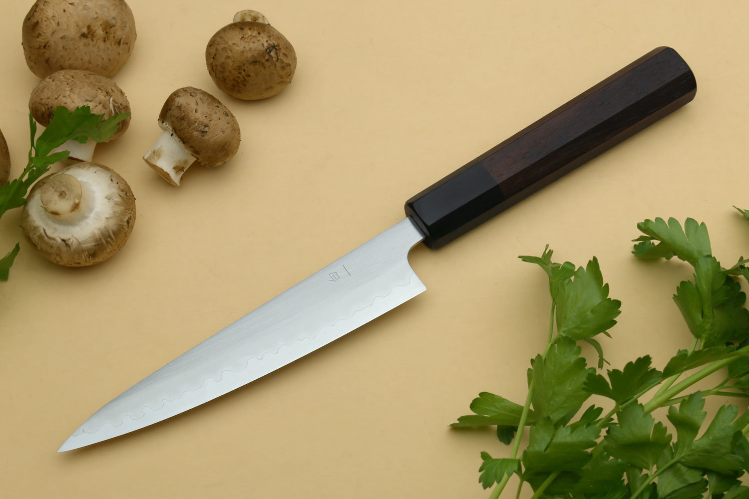 Stainless clad petty utility knife with silver blade and dark handle, side view