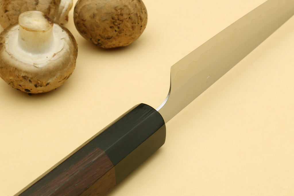 Petty utility knife handle close-up with dark wood grip and silver blade