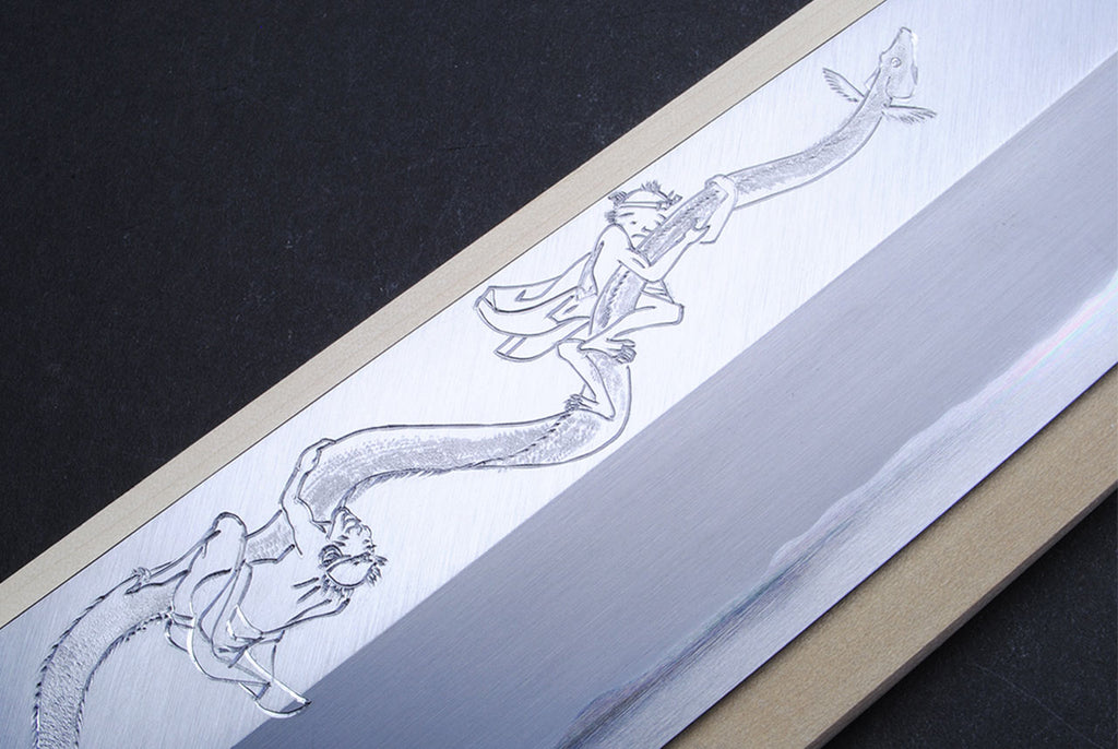 Japanese eel bone slicer knife, close view of engraved blade artwork.
