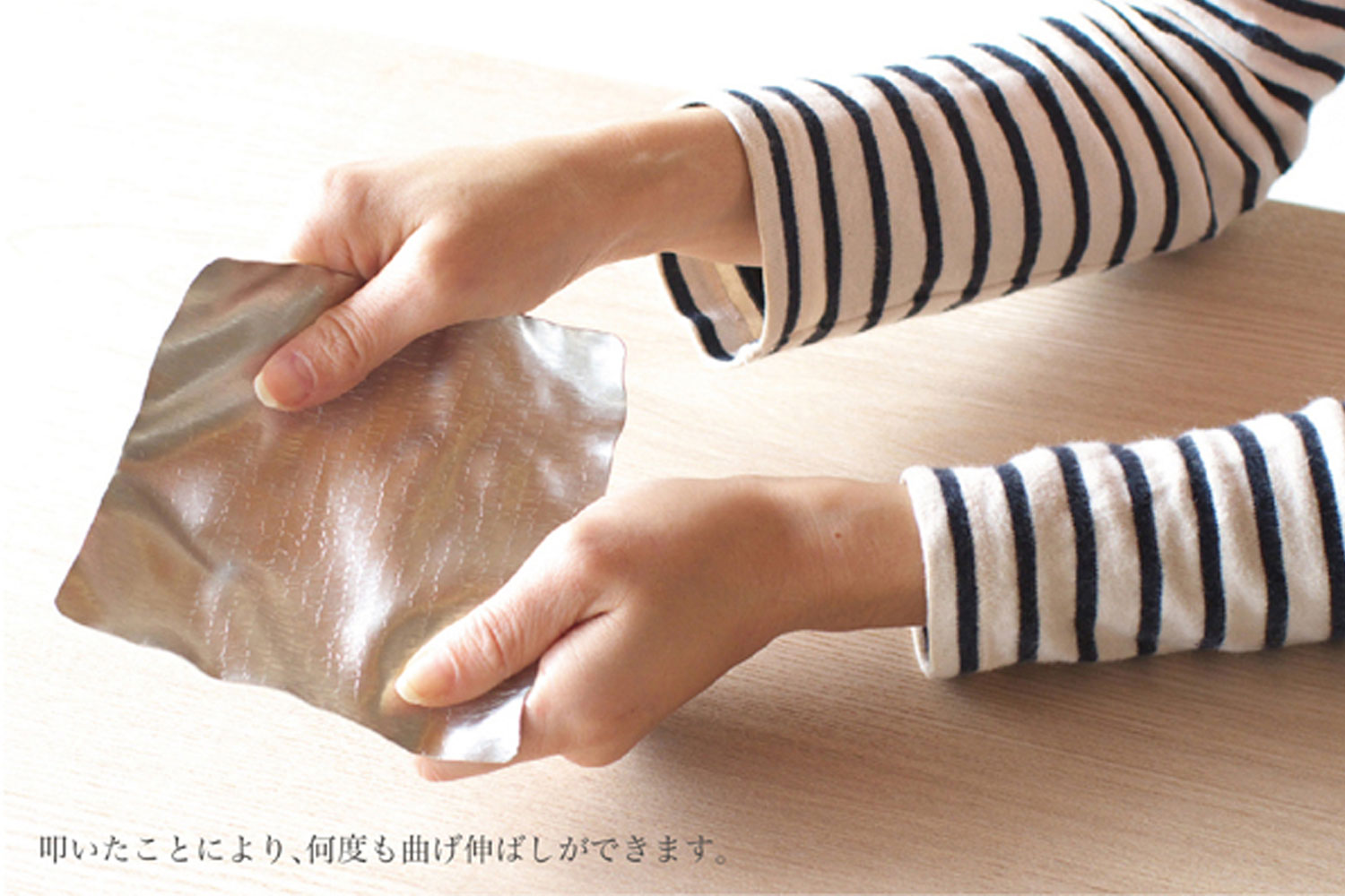 Wooden koro rolling stick used on a flexible tin plate, hands folding