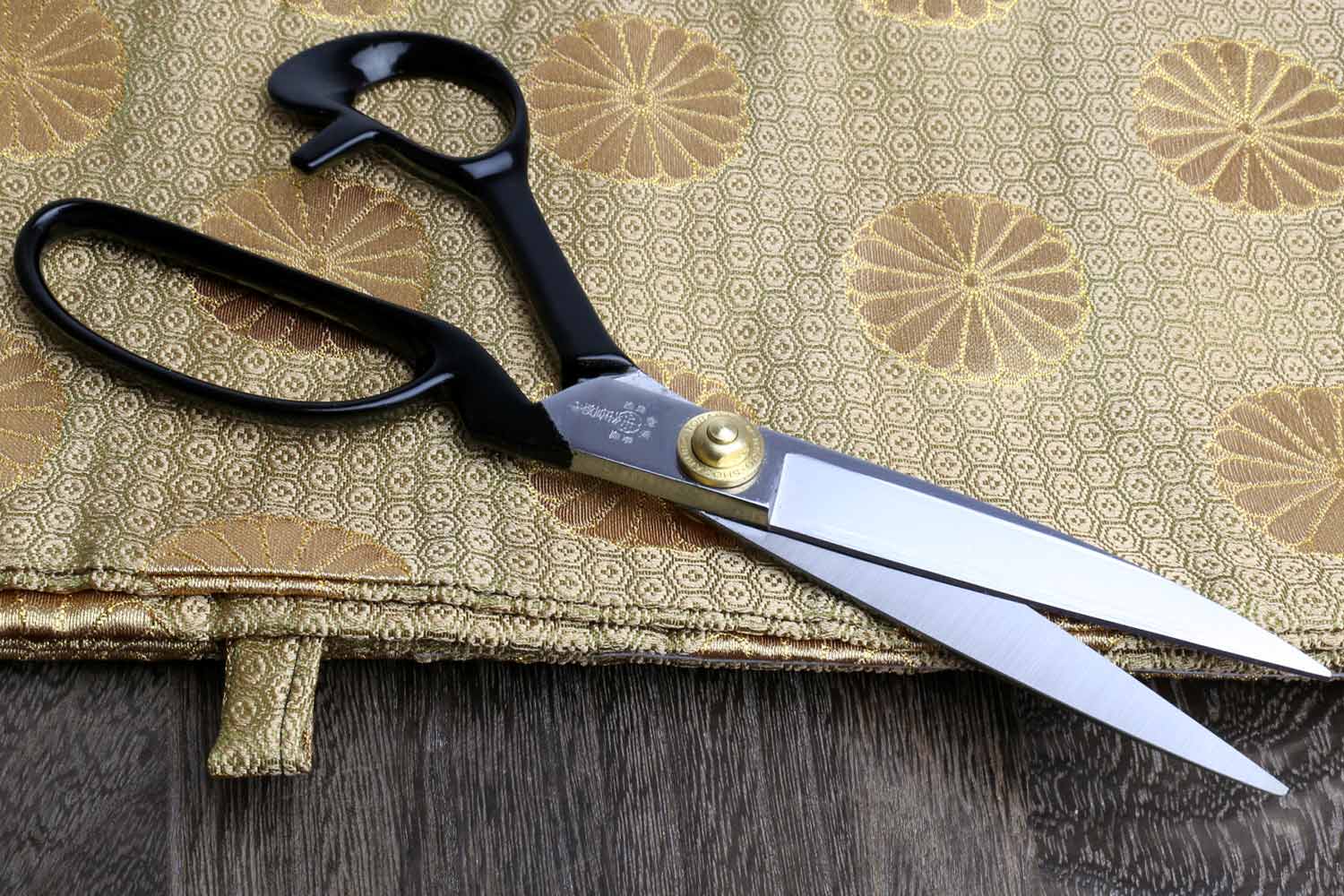 Right-handed fabric scissors with dark handles, silver blades, and gold pivot