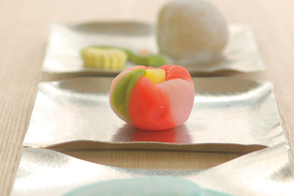 Flexible tin plate with a colorful mochi-like dessert centered on it