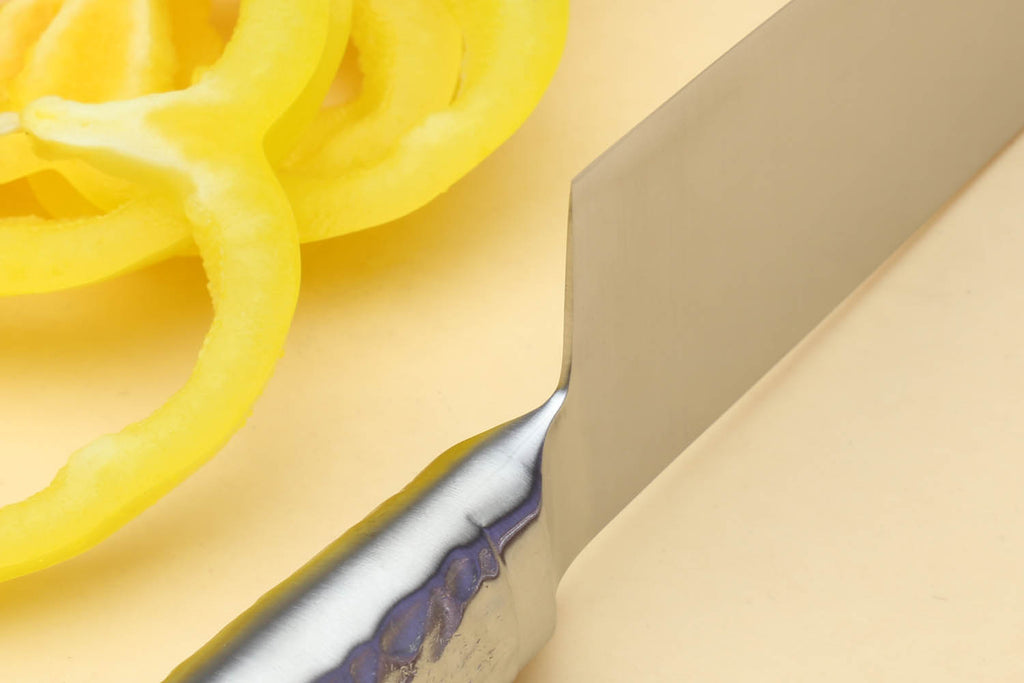Santoku chef's knife heel and blade transition with hammered steel and silver edge