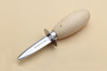 Stainless clam and oyster knife with light wood handle and pointed steel blade