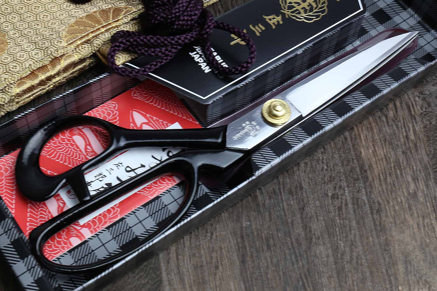 Fabric scissors with black handles, purple bow details, and silver blades