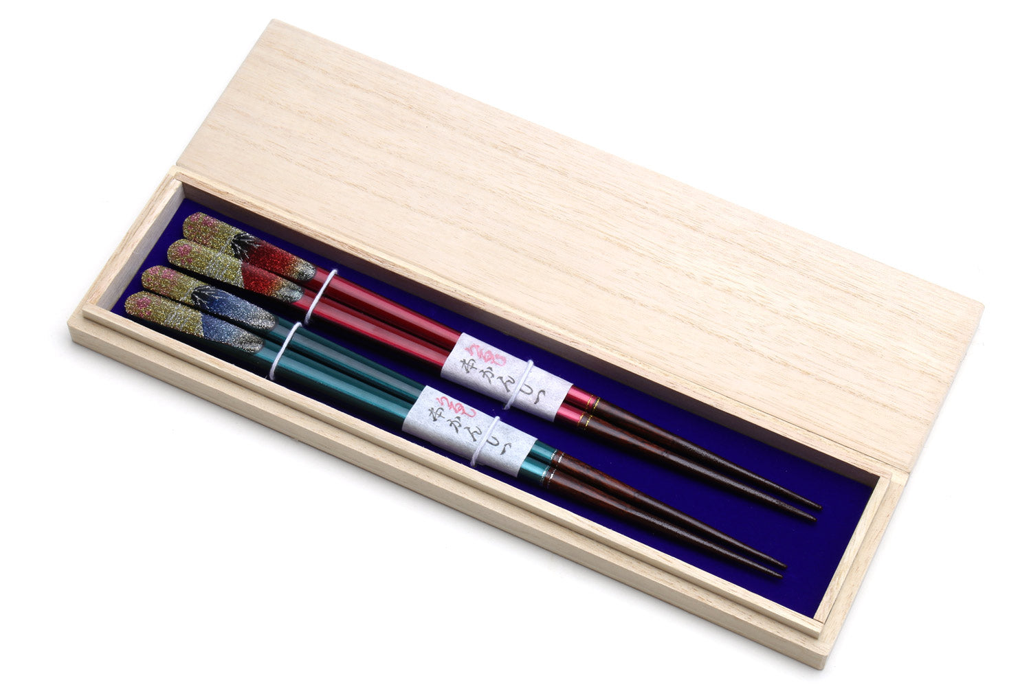 Glitter chopsticks in open pale wood box, showing red and teal pairs