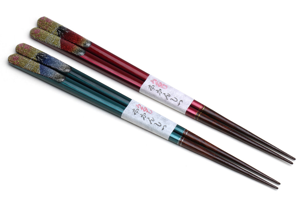Four glitter lacquer chopsticks with red, teal, and multicolor bands