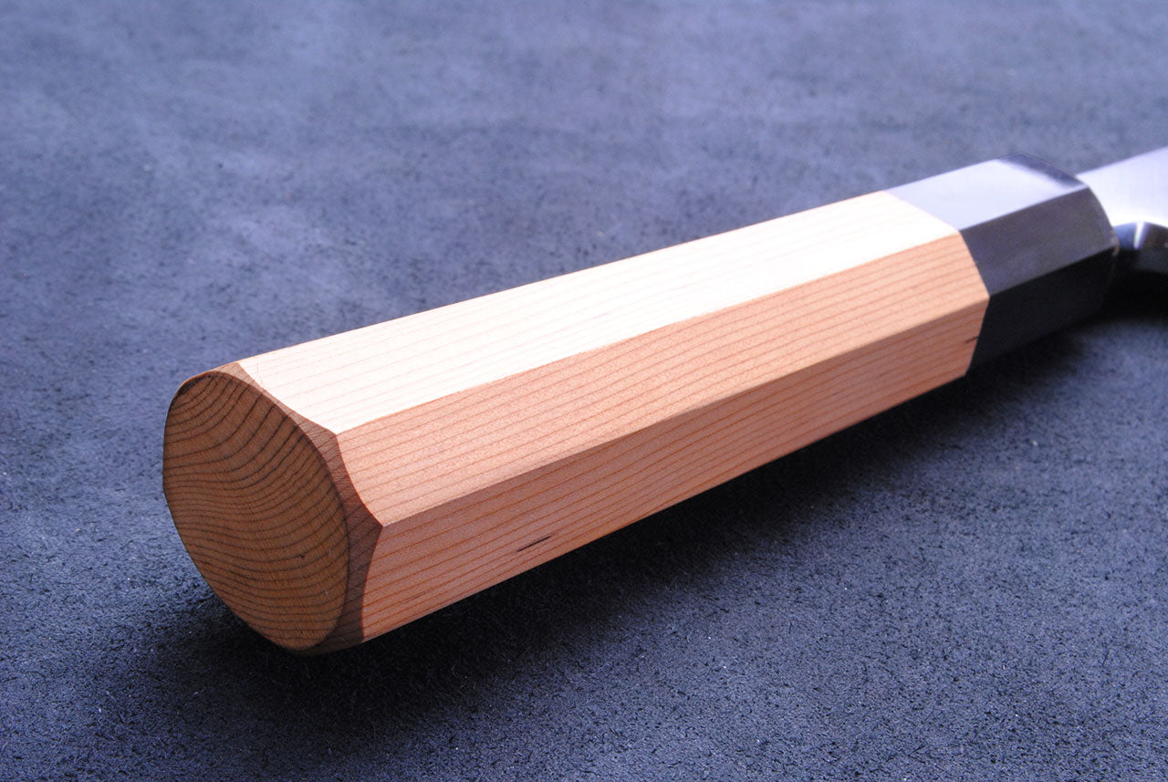 Japanese eel bone slicer knife with light yew wood handle and dark bolster.
