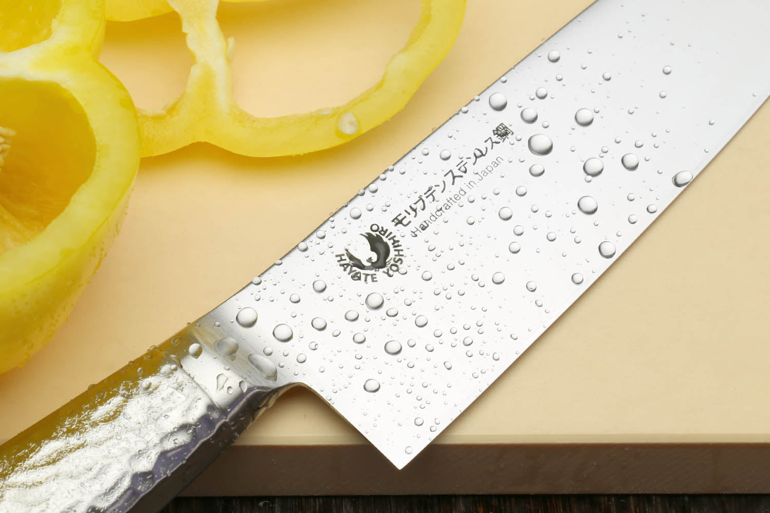Santoku chef's knife close-up of hammered blade with water droplets