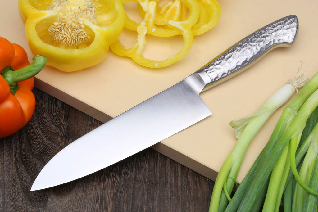 Santoku chef's knife angled view with hammered steel blade and stainless handle
