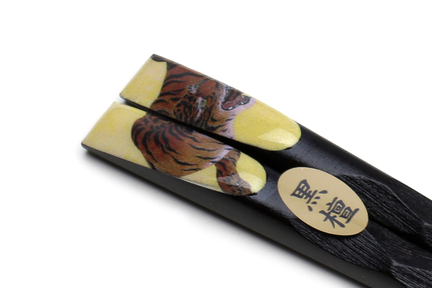 Lacquered ebony wood chopsticks with tiger artwork near the tips and round logo medallion