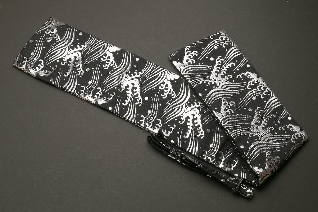 Knife pouch bag with black fabric and white Japanese wave pattern, folded with dark strap