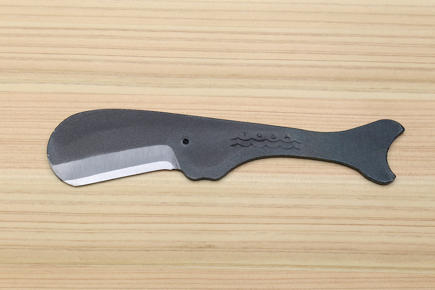 Utility knife side view with silver blade and dark kurouchi whale-shaped handle